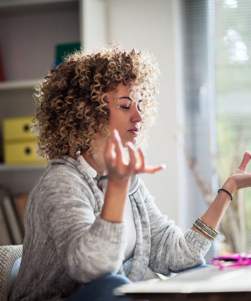 Young businesswoman meditating  in her office